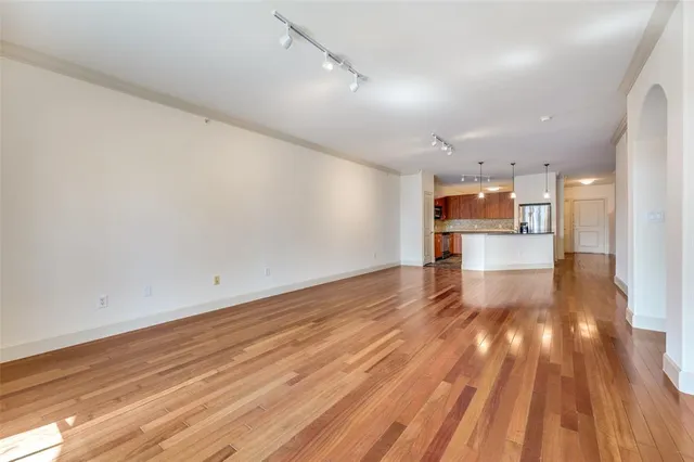 a view of empty room with wooden floor