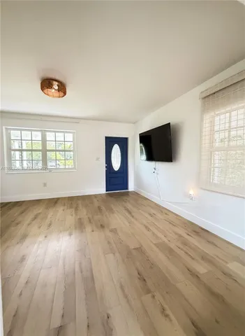 a view of hallway with a door and wooden floor