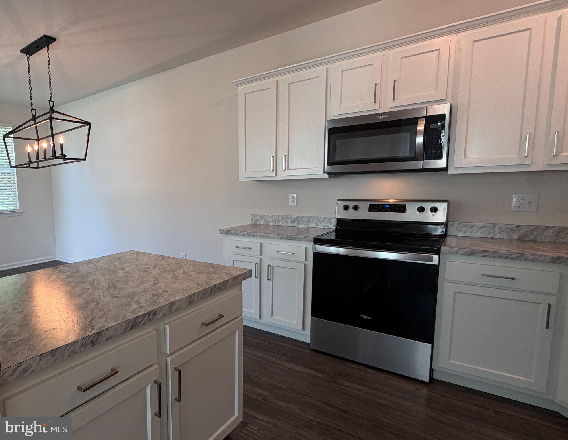 78 Tansboro Road Berlin, NJ 08009 - Photo 15 of 41 a kitchen with white cabinets and black appliances
