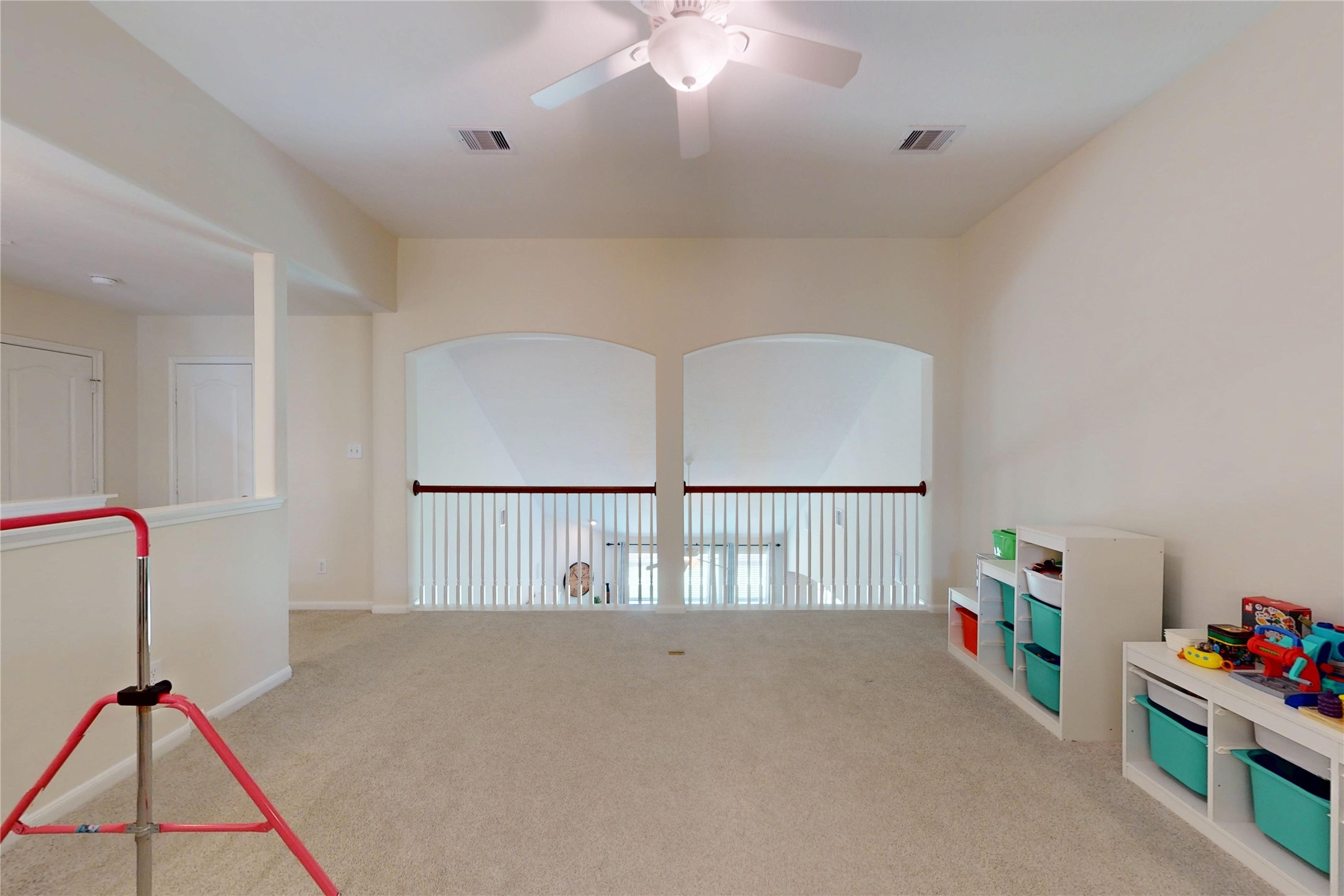 17402 Rainer Valley Lane Humble, TX 77346 - Photo 20 of 33 This spacious playroom features neutral carpeting, a ceiling fan, and natural light from an open railing overlooking the space below. It's ideal for a playroom or additional living area or storage for toys or supplies.