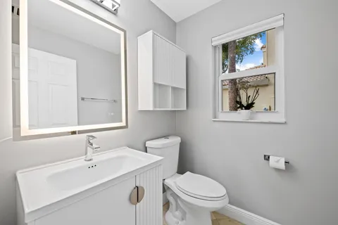 a bathroom with a granite countertop sink a mirror a bathtub and shower