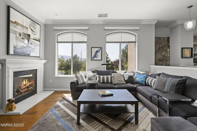 a living room with furniture a fireplace and a large window