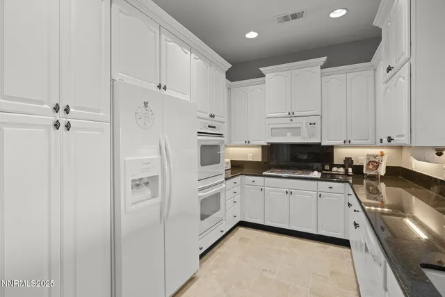 a kitchen with white cabinets and white appliances