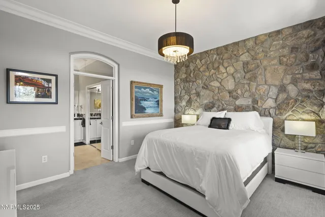 a spacious bedroom with a bed and a chandelier