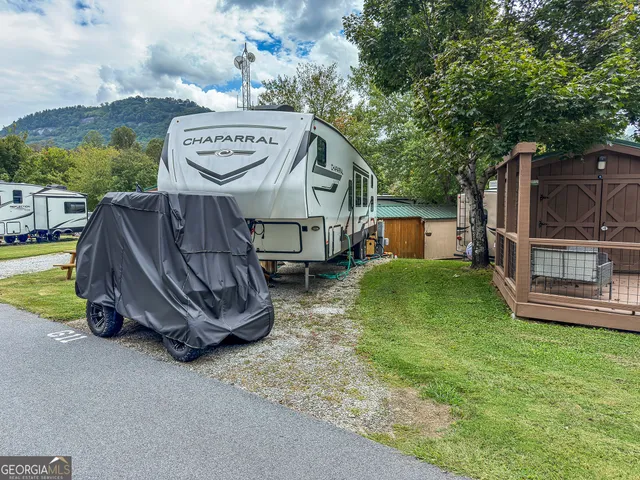 a view of a house with a yard and deck area