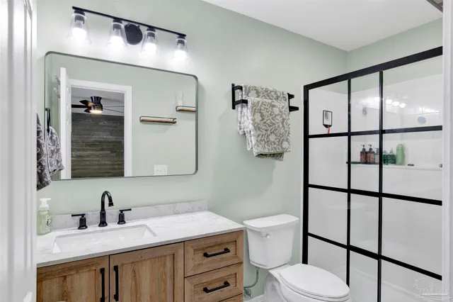 a bathroom with a sink vanity mirror and toilet