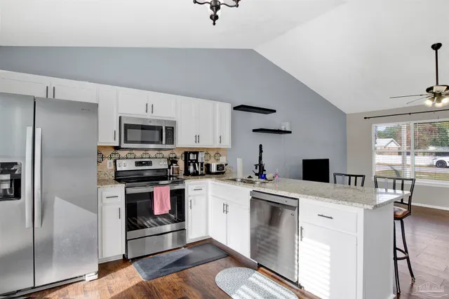 a kitchen with kitchen island a stove a sink and a refrigerator