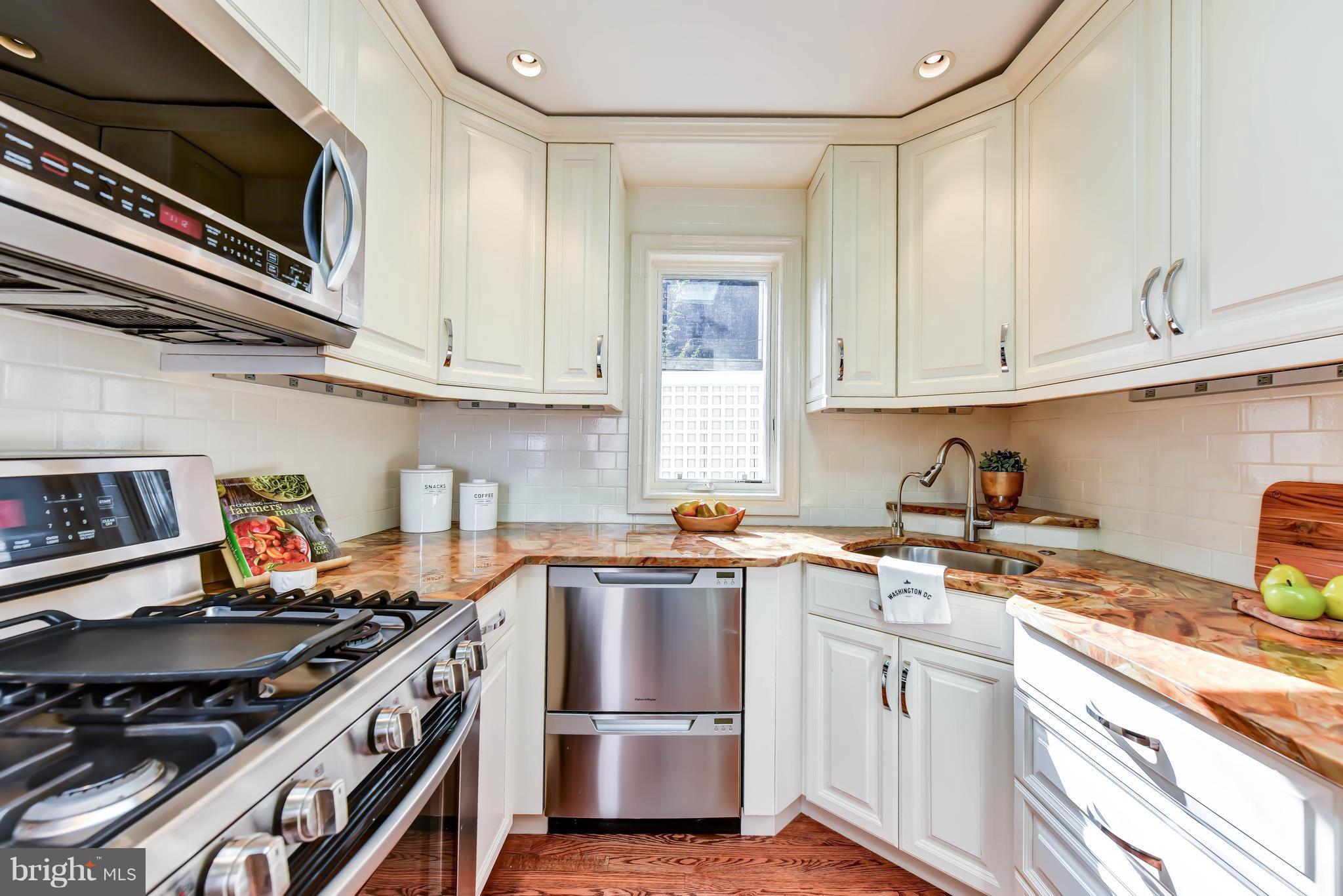21 3rd Street Northeast Washington, DC 20002 - Photo 10 of 29 a kitchen with stainless steel appliances a stove a sink and cabinets