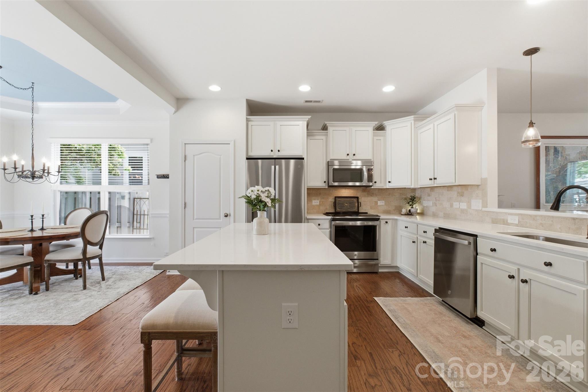 22237 Market Street Cornelius, NC 28031 - Photo 14 of 45 a large kitchen with kitchen island a sink table and chairs