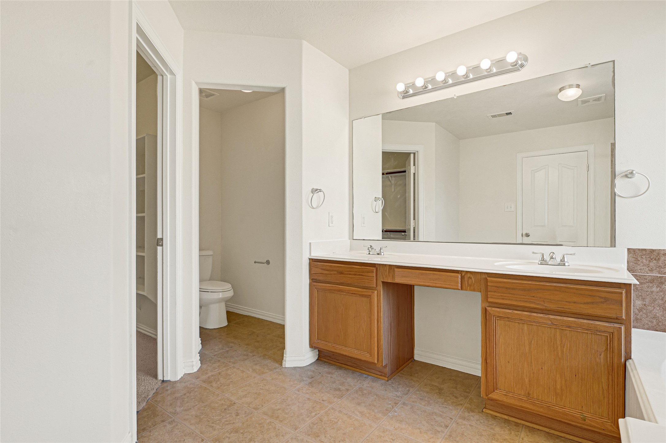 5010 Dartmoor Ridge Trail Houston, TX 77066 - Photo 17 of 28 a spacious bathroom with a granite countertop sink mirror and toilet