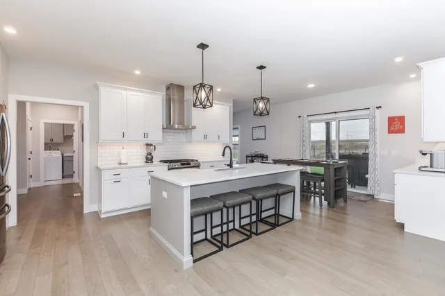 a kitchen with kitchen island a stove a sink a center island and windows