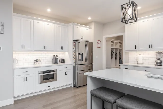 a kitchen with white cabinets and stainless steel appliances