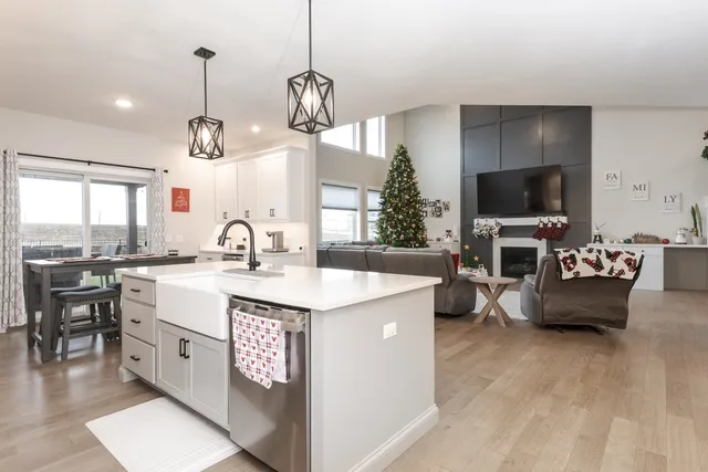 a large living room with stainless steel appliances kitchen island granite countertop a sink and a flat screen tv