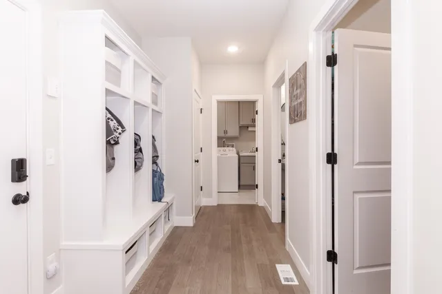 a view of a hallway with white walls and wooden floor