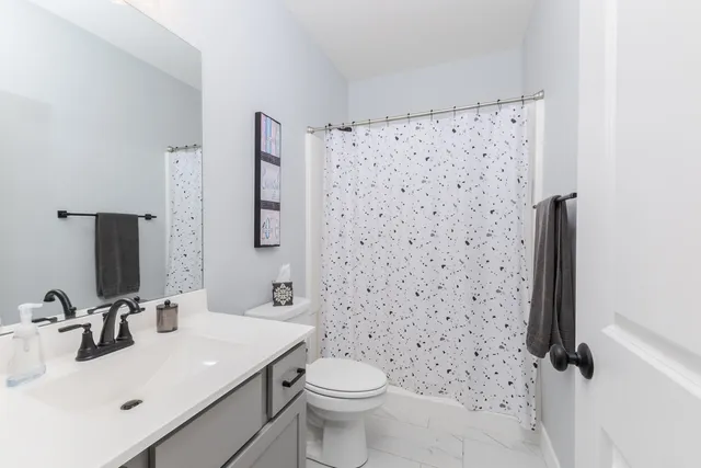 a bathroom with a sink toilet and shower