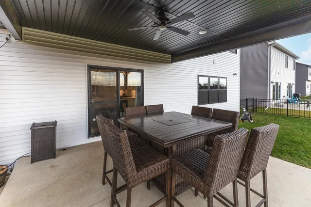 a view of a dining table and chairs in back of a house