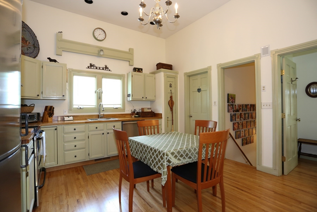 24 Pershing Road, Unit 24 Needham, MA 02494 - Photo 8 of 39 a kitchen with granite countertop kitchen island wooden floor center island and stainless steel appliances