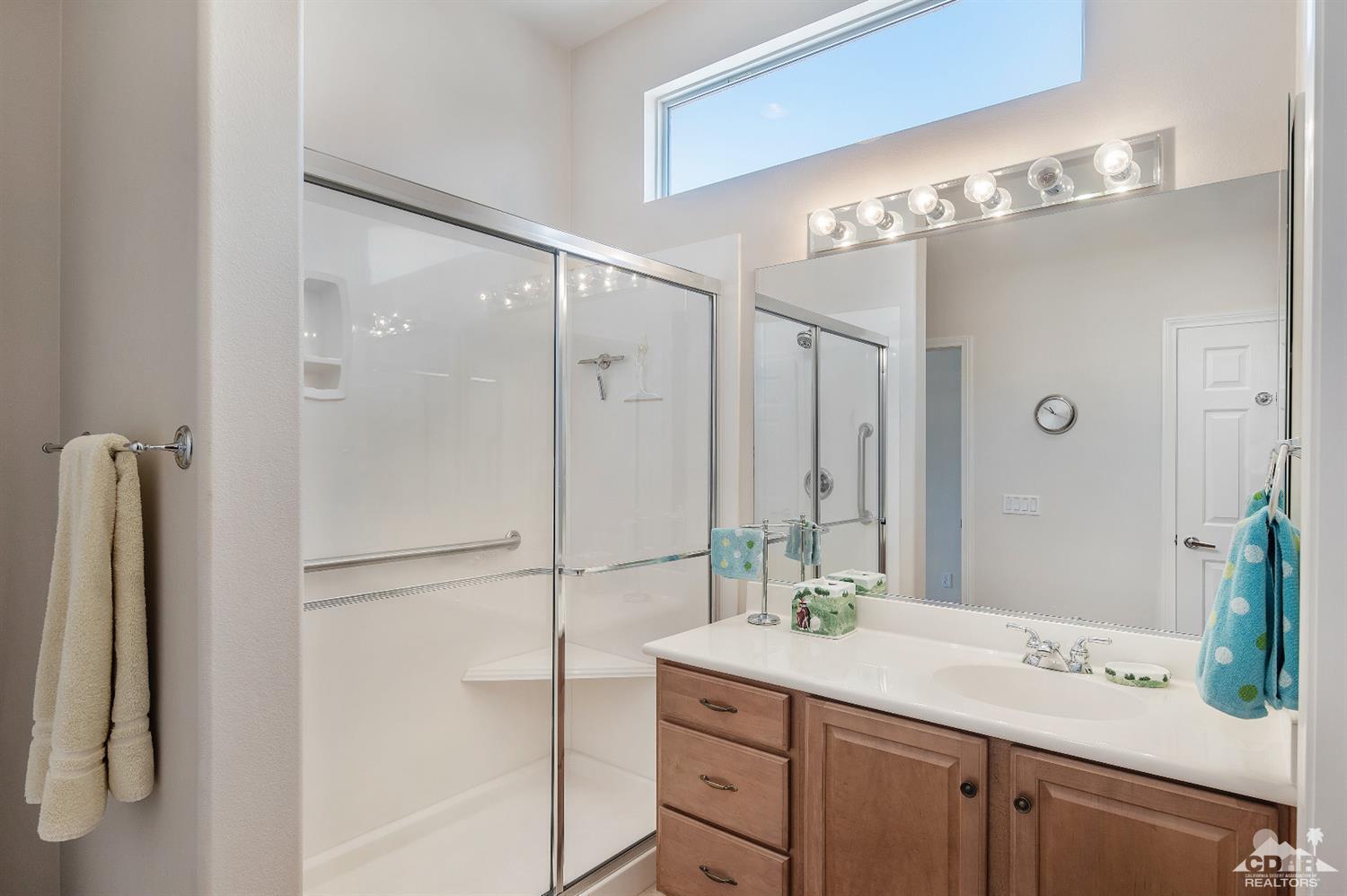 80557 Knightswood Road Indio, CA 92201 - Photo 29 of 30 a bathroom with a granite countertop sink a shower and a mirror