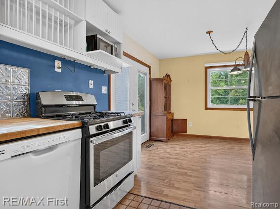 56375 Bates Road New Baltimore, MI 48051 - Photo 21 of 35 Stainless steel range, wood-finish countertops, white upper cabinetry, and wood-finish flooring