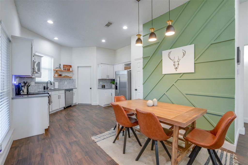 a kitchen with a table chairs refrigerator and microwave