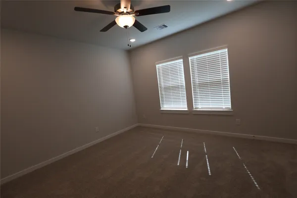 an empty room with a window and a fan