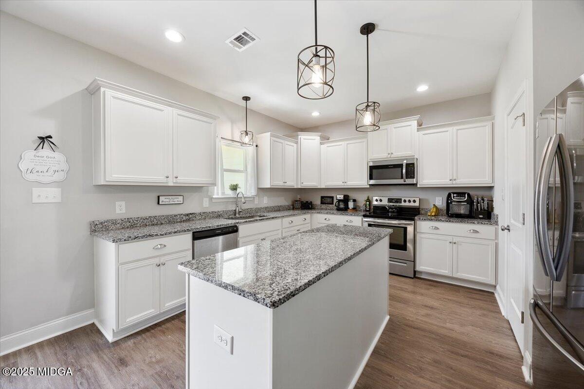 309 Davis Road Gray, GA 31032 - Photo 13 of 48 a kitchen with kitchen island granite countertop stainless steel appliances cabinets a sink and a center island