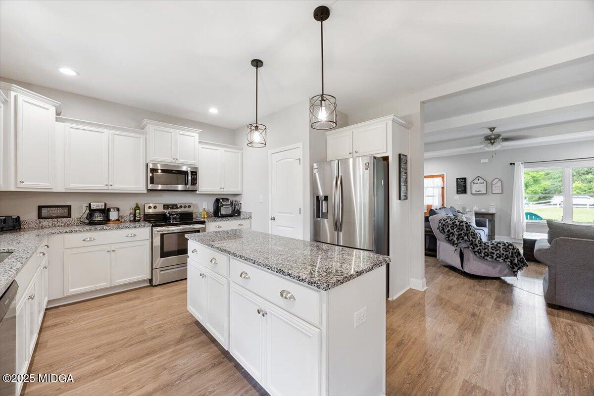 309 Davis Road Gray, GA 31032 - Photo 15 of 48 a kitchen with stainless steel appliances granite countertop a refrigerator a sink dishwasher a stove and white cabinets with wooden floor