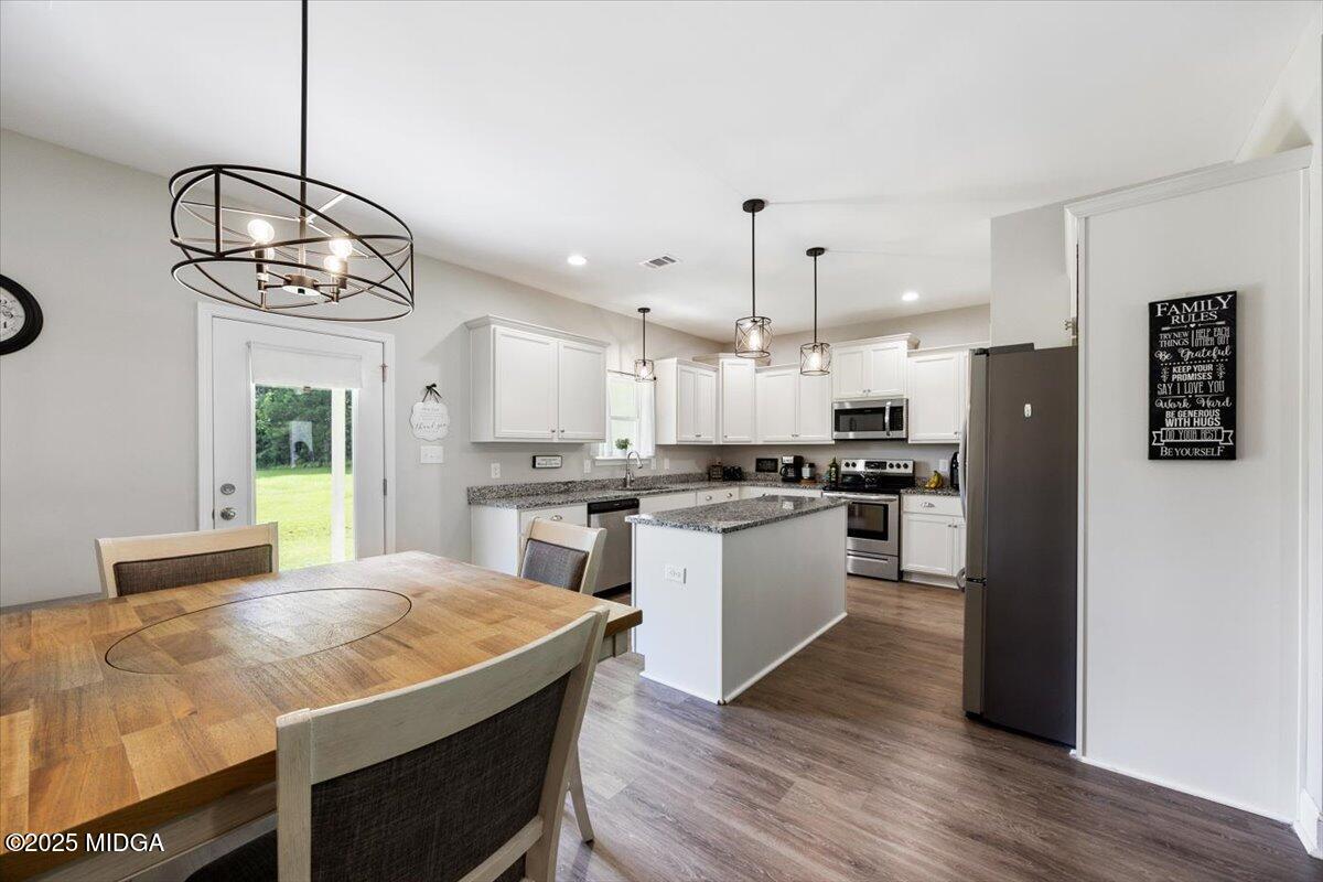 309 Davis Road Gray, GA 31032 - Photo 9 of 48 a kitchen with a refrigerator a kitchen island a stove and wooden floor