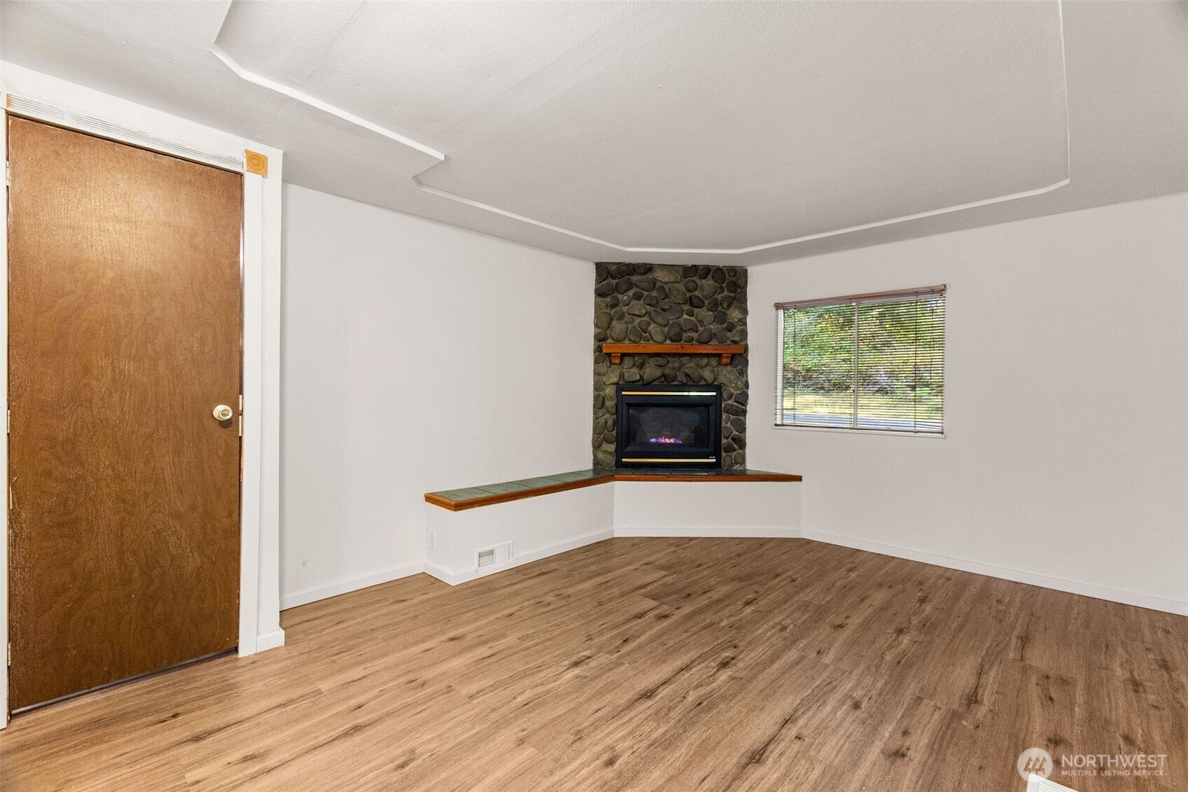 4312 Meridian Road Northeast Lacey, WA 98516 - Photo 13 of 21 an empty room with wooden floor a fireplace and windows