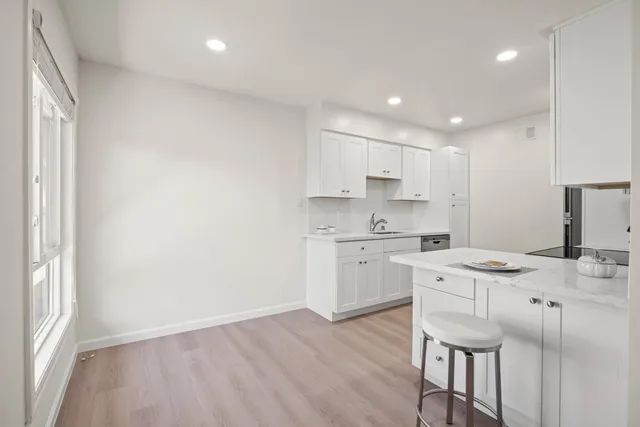 a kitchen with a stove a sink a dining table and chairs