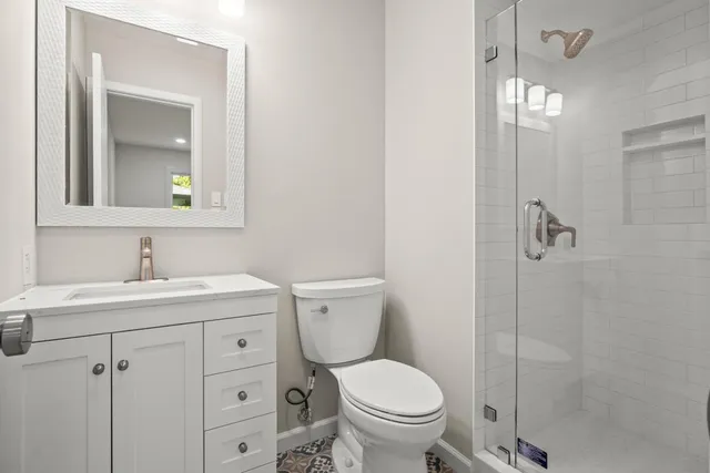 a bathroom with a toilet sink vanity and granite