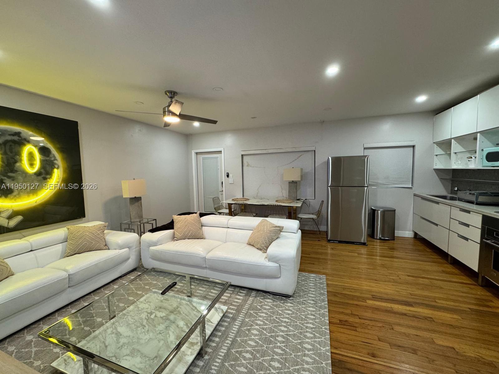 101 Collins Avenue, Unit 3 Miami Beach, FL 33139 - Photo 1 of 4 a living room with furniture and a flat screen tv