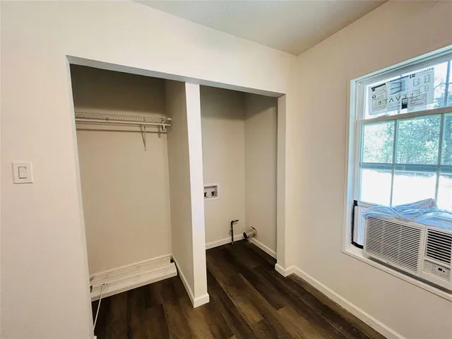 a view of a hallway with wooden floor and a window