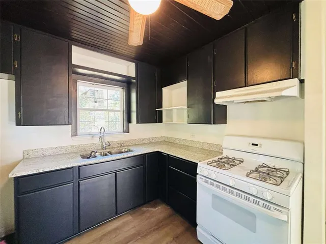 a kitchen with a sink a stove and cabinets