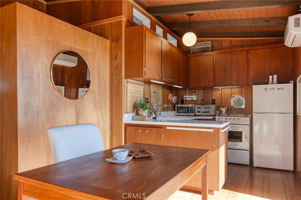 3105 Knob Street Nice, CA 95464 - Photo 12 of 36 a kitchen with a refrigerator a stove a sink and a dining table with wooden floor