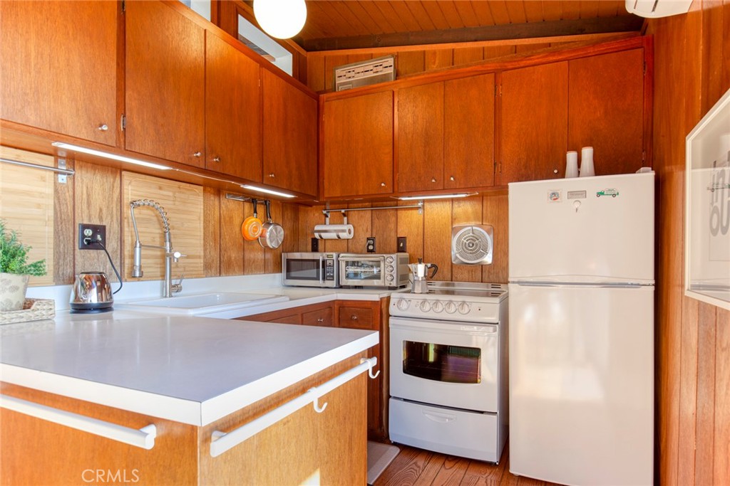 3105 Knob Street Nice, CA 95464 - Photo 16 of 36 a kitchen with a refrigerator a stove and a microwave with wooden floor