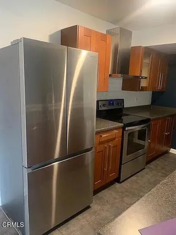 a metallic refrigerator freezer sitting in a kitchen