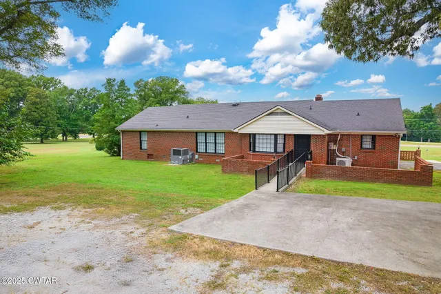a view of a house with a yard and a patio