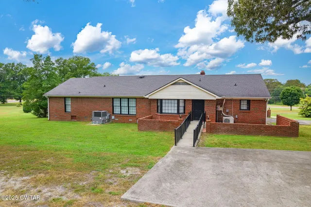 a front view of a house with yard and green space