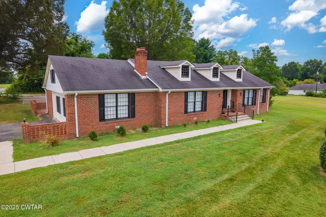 a aerial view of a house with a yard potted plants and large tree