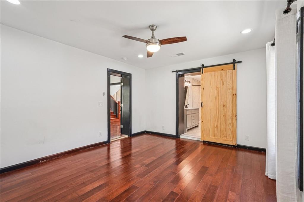 1689 Derry Avenue Southwest Atlanta, GA 30310 - Photo 24 of 51 a view of an empty room with wooden floor and a ceiling fan