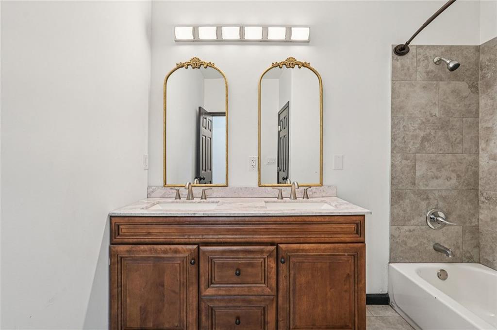 1689 Derry Avenue Southwest Atlanta, GA 30310 - Photo 36 of 51 a bathroom with a granite countertop sink a mirror and a bathtub