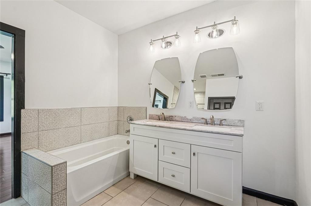 1689 Derry Avenue Southwest Atlanta, GA 30310 - Photo 41 of 51 a bathroom with a granite countertop sink mirror and bathtub