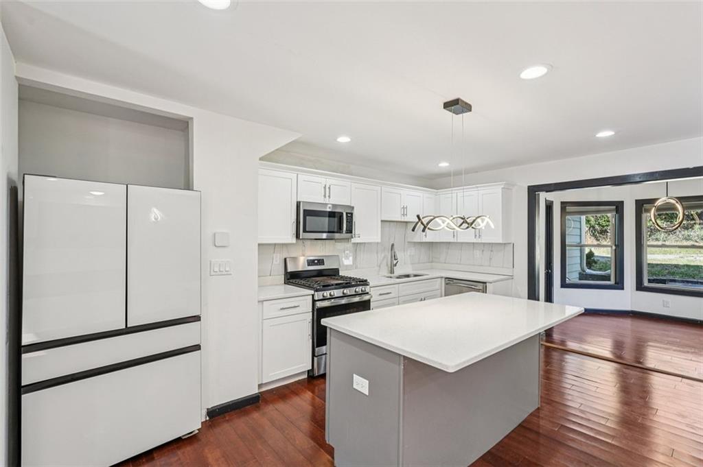 1689 Derry Avenue Southwest Atlanta, GA 30310 - Photo 10 of 51 a kitchen with stainless steel appliances a stove a refrigerator a sink and white cabinets with wooden floor