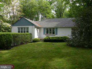 a front view of a house with a yard and trees