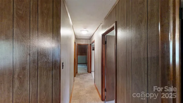 an empty room with windows closet and chandelier fan
