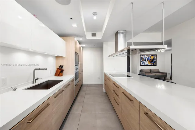 a large white kitchen with a stove and a sink