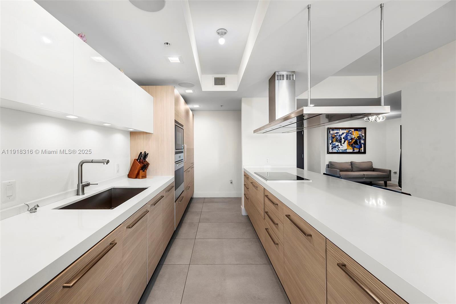 17111 Biscayne Boulevard, Unit 606 North Miami Beach, FL 33160 - Photo 14 of 36 a large white kitchen with a stove and a sink