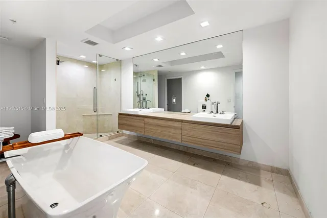 a bathroom with a double vanity sink mirror and bathtub