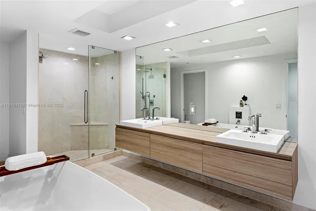 a spacious bathroom with a double vanity sink mirror and shower